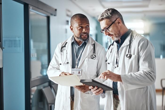 Two physicians consulting in a hospital hallway